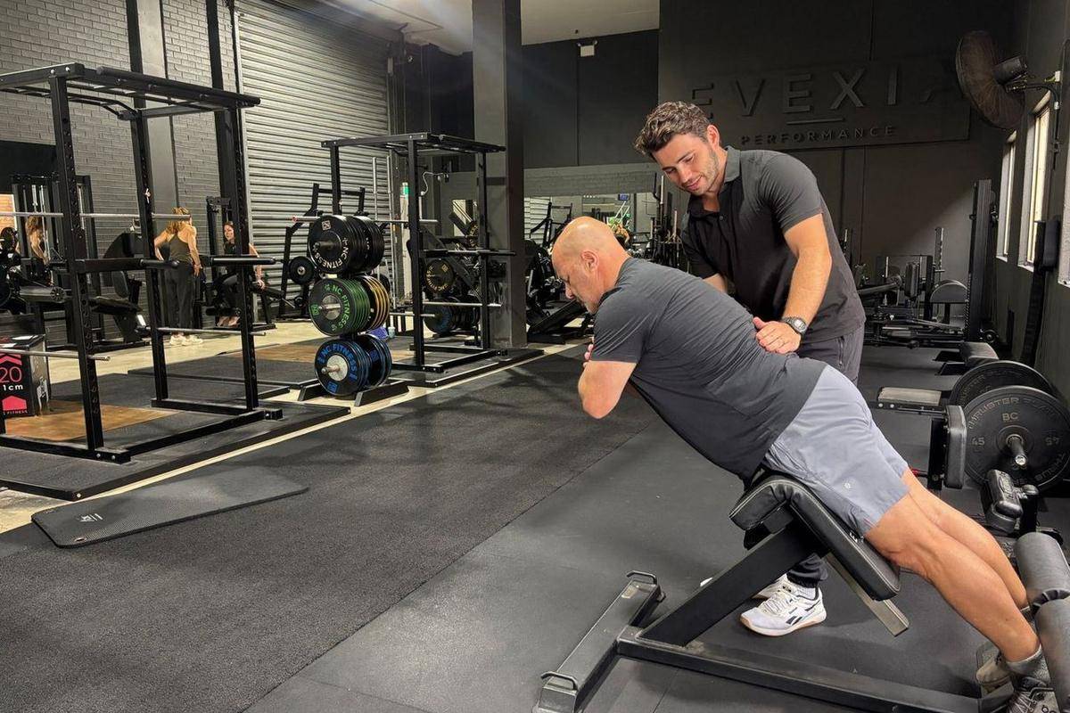 Max coaching a client through a back extension, strength work that protects muscle after 40