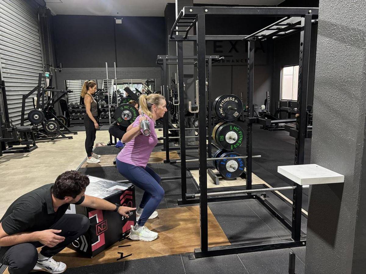 Max coaching a client through a box squat