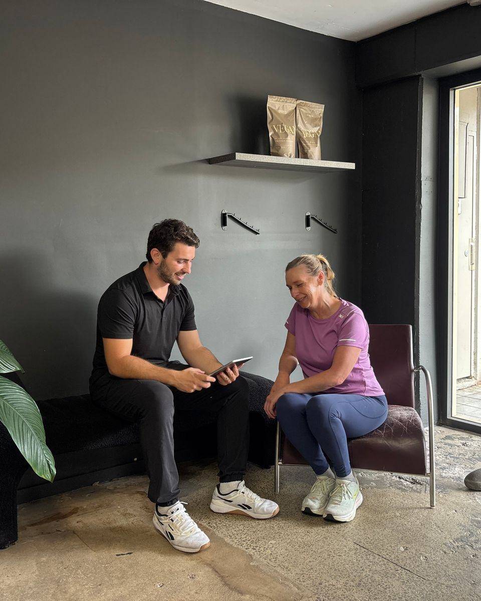 Weight Loss Coaching Northern Beaches — Solve PT Max going through a nutrition plan with a client on an iPad at Solve Personal Training