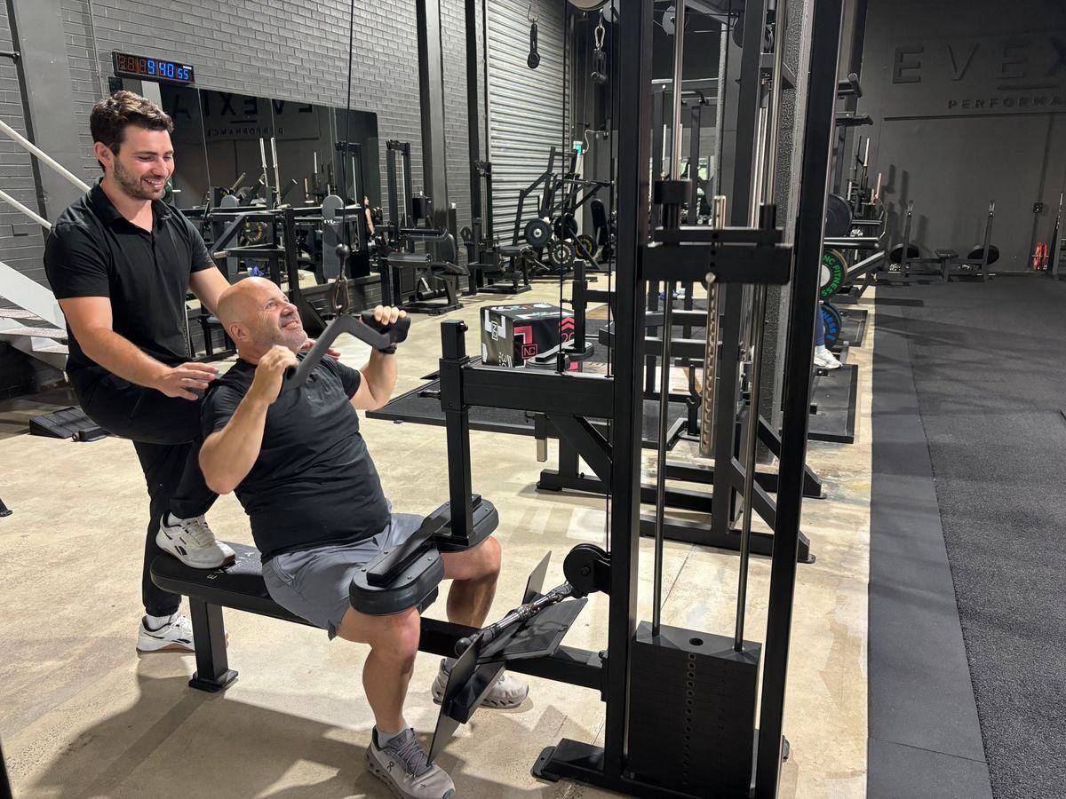 Weight Loss Coaching Northern Beaches — Solve PT A client on the lat pulldown with Max coaching, training that protects muscle while losing fat